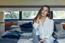 Beautiful Woman Sitting On A Bed