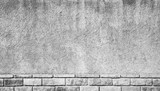 Fototapeta Młodzieżowe - Gray grungy concrete wall with brick base