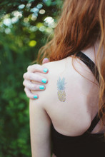 A Teenage Girl With A Tattoo Of A Pineapple