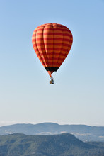 Alone Hot Air Balloon Flying Over A Blue Sky