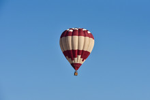 Alone Hot Air Balloon Flying Over A Blue Sky