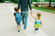 © Maria Manco/Stocksy - children walk with dad holding hands
