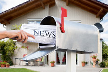Hand Taking Newspaper From Mailbox