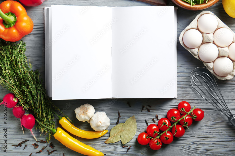Open notebook and vegetables on kitchen table. Cooking classes concept