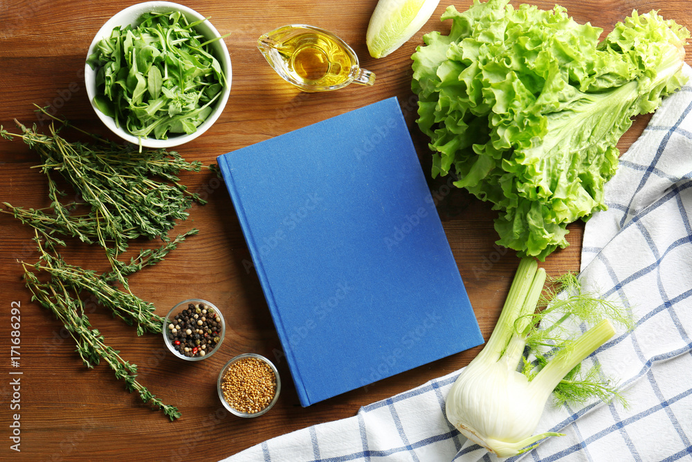 Notebook and vegetables on kitchen table. Cooking classes concept