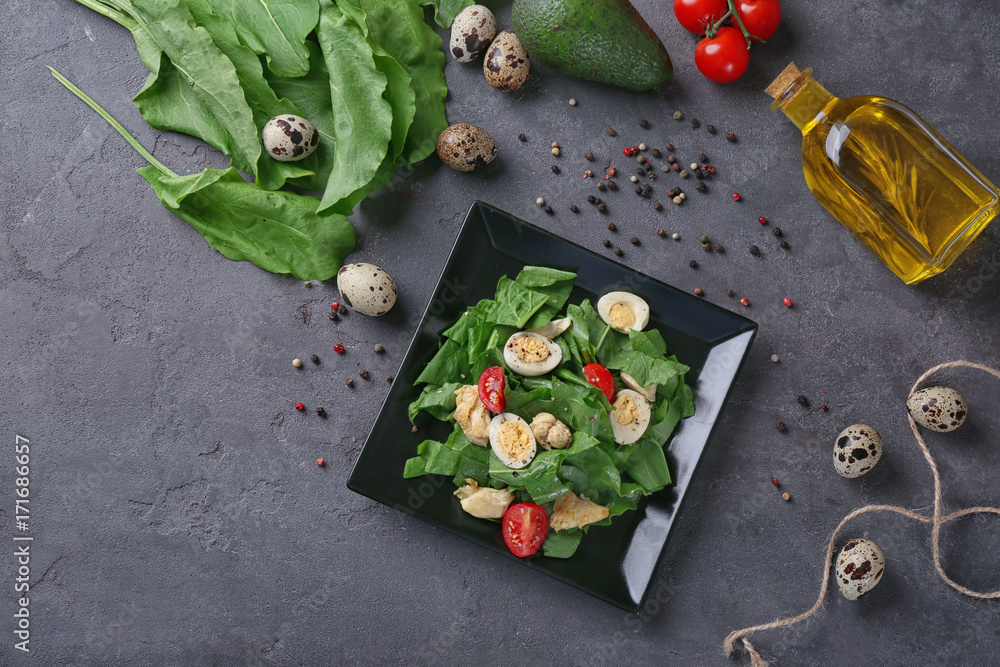 Plate of salad with quail eggs and spinach on table