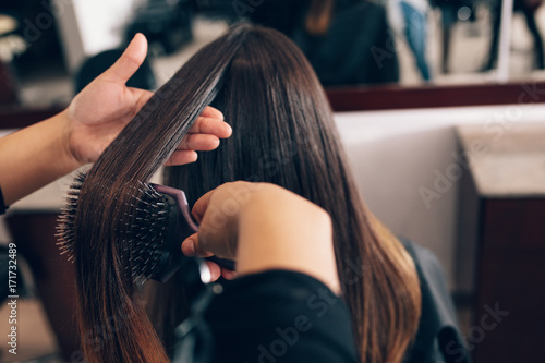 Female Hair Stylist Working On A Woman S Hair At Salon Buy This