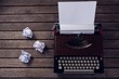 Vintage typewriter and crumbled paper on wooden table
