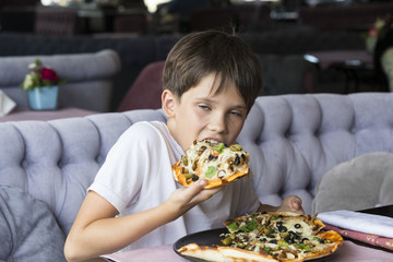 The boy is eating pizza in an Italian restaurant 