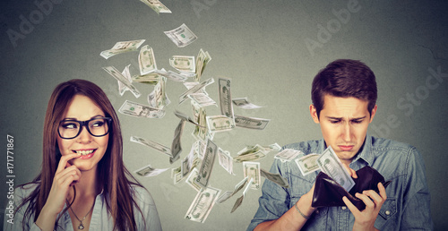 Fotografía Sad man looking at his wallet with money dollar banknotes flying away towards fl