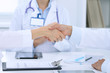 © rogerphoto - Doctors shaking hands to each other finishing up medical meeting