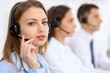 © rogerphoto - Call center operators. Focus at young beautiful business woman in headset