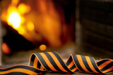 Fototapeta  - St. George's ribbon on a blurred fire background. 9th May