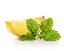 Slice Of A Fresh Juicy Lemon With Mint Leaves On A White Background.