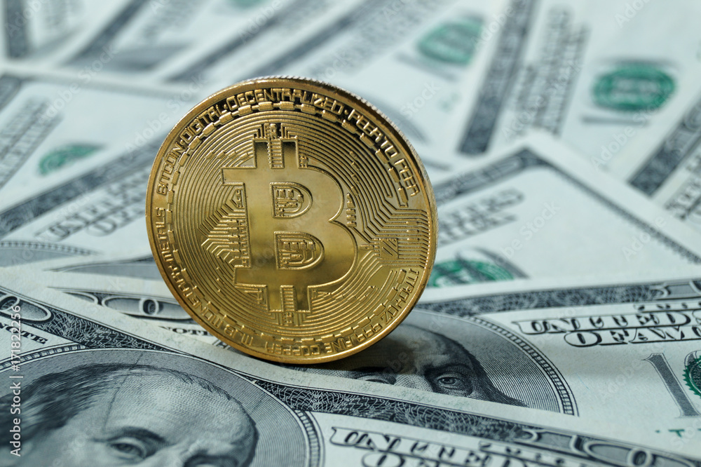 A symbolic coins of bitcoin on banknotes of one hundred dollars.