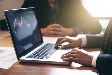 Business team two colleagues working with computer, digital tablet, discussing and analysis graph stock market trading with stock chart data, financial and investment concept