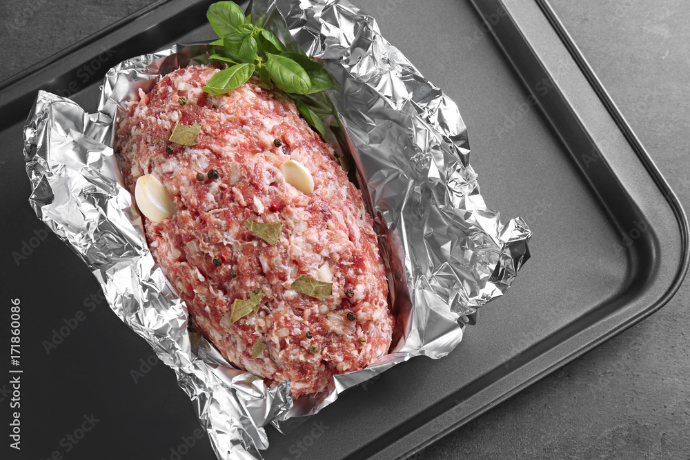 Baking tray with raw turkey meatloaf on table