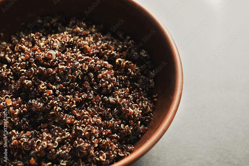 Bowl with boiled quinoa grains on kitchen table