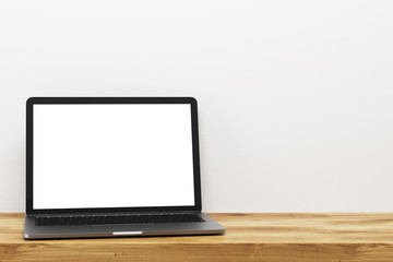 Wall Mural - Laptop on a wooden table, white wall