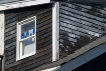 New England House With Blue Bottles In Window