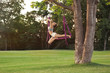 © Africa Studio - Young woman practicing aerial yoga on tree in park