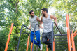© Kzenon - Zwei gute Freunde trainieren dips für Fitness im Outdoor Gym
