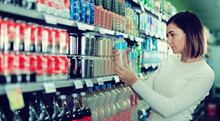 Woman Choosing Refreshing Beverages In Supermarket