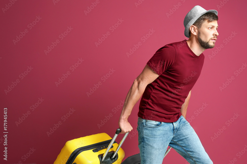 Man with overweight luggage on colorful background