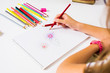 © creativefamily - Girl drawing a colorful flower first person