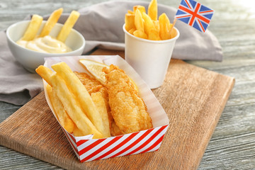 Sticker - Paper box with tasty fried fish and potato chips on wooden table