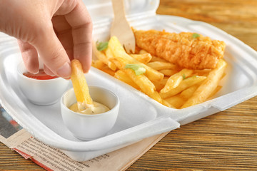 Wall Mural - Woman dipping chips into sauce, closeup