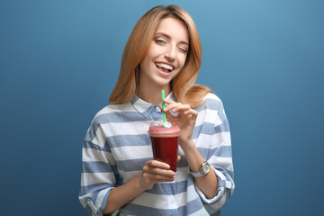 Poster - Beautiful young woman with fresh smoothie on color background