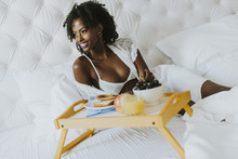 Smiling African American Woman Having A Relaxing Breakfast In Bed At Home