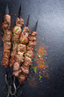 © HLPhoto - Traditional Russian shashlik on a barbecue skewer as top view on slate slab