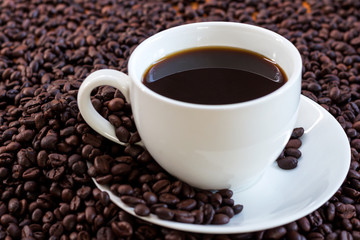 Hot coffee in white cup and coffee beans