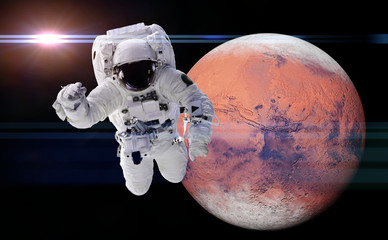 Wall Mural - astronaut performing a space walk around the red planet mars