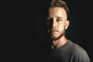 portrait of young man above black background