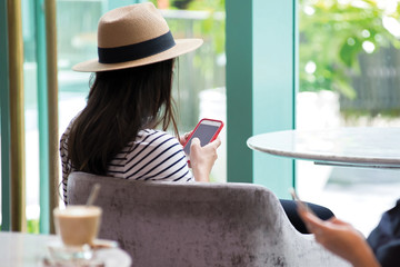 Woman using mobile phone sit on sofa at hotel lobby