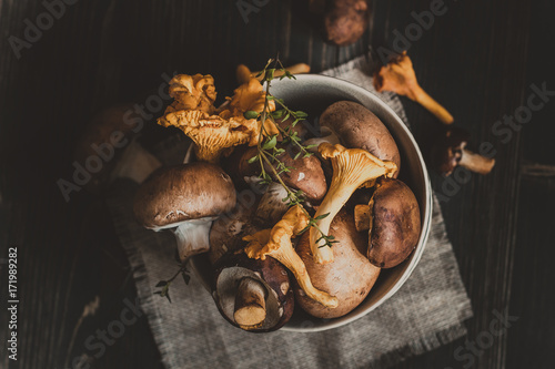 Fotografía Fresh mixed forest mushrooms on the wooden black table