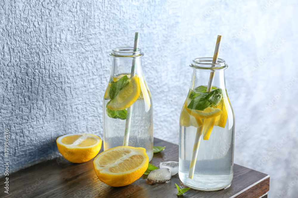 Bottles with basil water on table