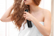 © Africa Studio - Beautiful young woman after bath with spray for hair on blurred background