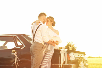 Poster - Happy wedding couple near decorated car, outdoors