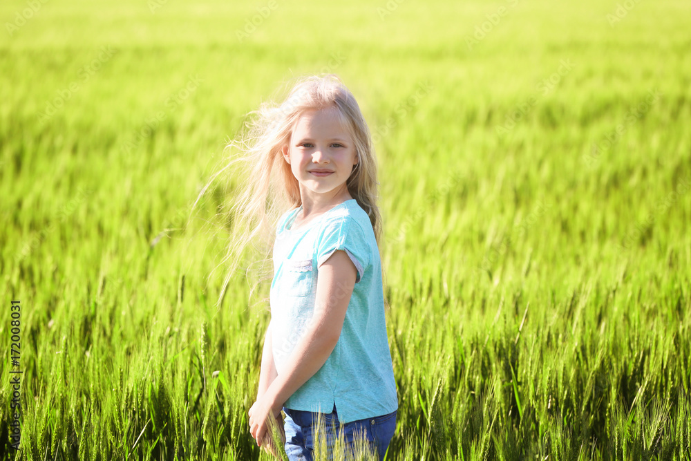 Happy little girl in green field
