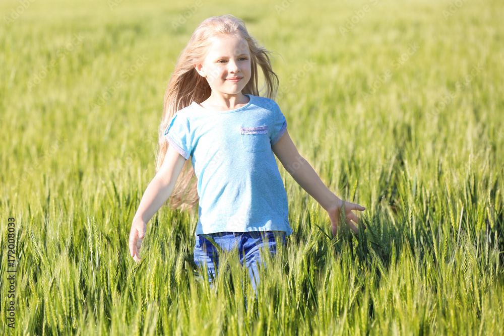 Happy little girl in green field