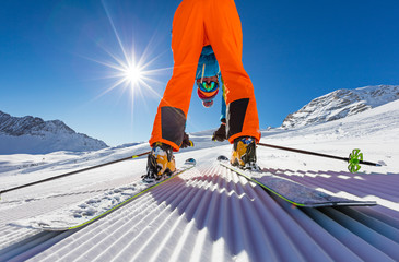 Skier posing on piste in high mountains