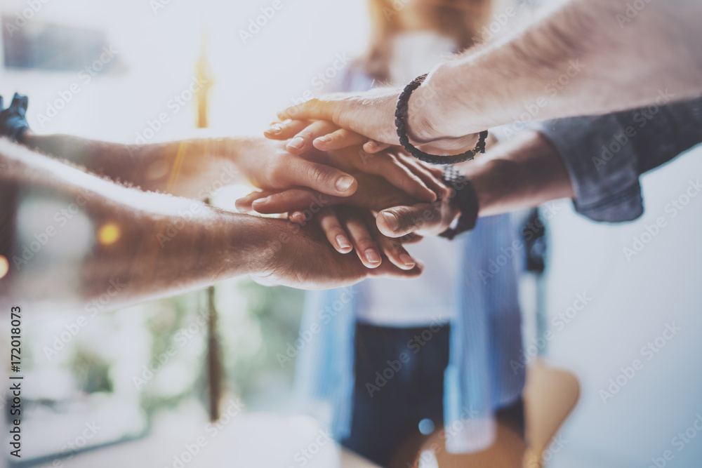 Teamwork business concept.Close up view of group of three coworkers join hand together during their meeting. Horizontal.Blurred background.