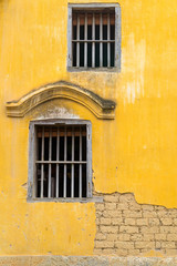 Wall Mural - The old wooden window on yellow ancient brick wall