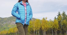 Autumn Nature Lifestyle Happy Asian Woman Relaxing Outdoors On Travel In Mountains. Hiking Girl Wearing Blue Down Jacket Enjoying Fall Season Scenic Landscape. Laurentides, Charlevoix, Quebec, Canada