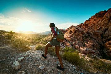 Wall Mural - woman hiking at red rock canyon during sunset with backpack