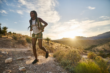 Wall Mural - woman hiking at red rock canyon during sunset with backpack